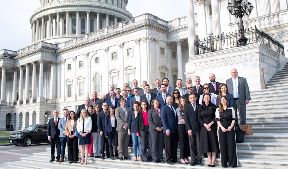 Large group of beer industry professionals and advocates standing on the steps of the U.S. Capitol, participating in a Hill Day event to promote the economic impact of the beer industry.