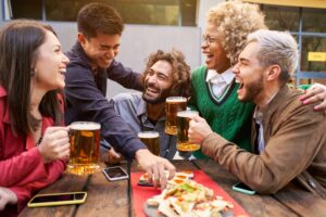 Gathering with friends enjoying beers and food.
